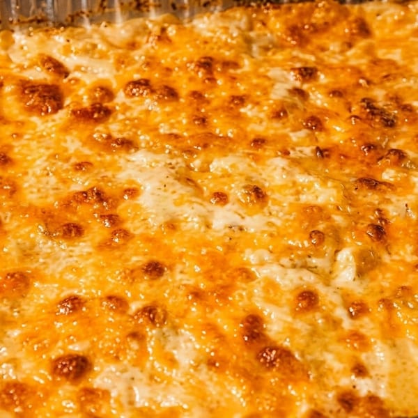 Golden-brown baked macaroni and cheese in a foil pan, ready to serve.